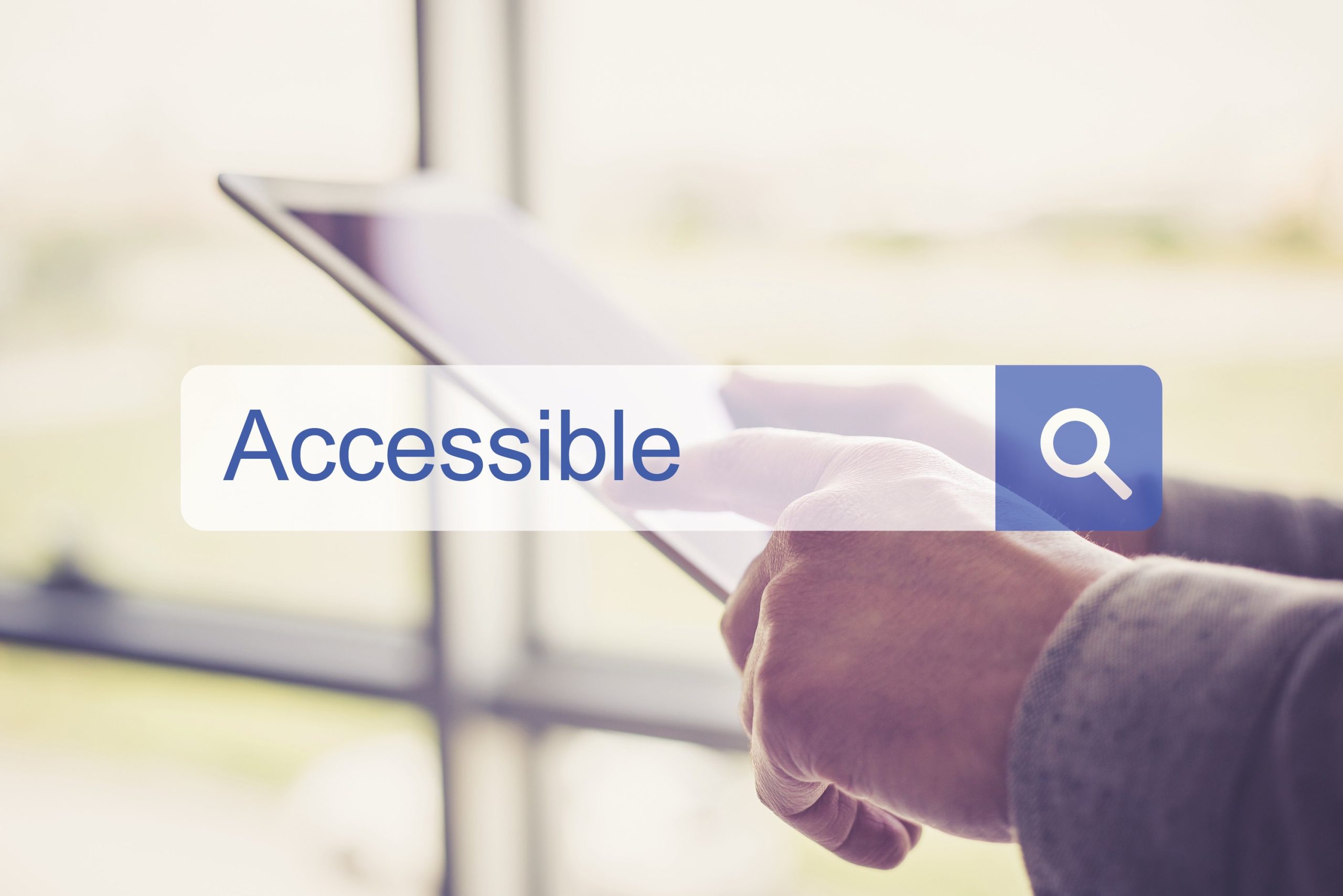 recuadro de búsqueda con la palabra accesible en inglés, de fondo vemos unas manos que interactúan con una tableta electrónica