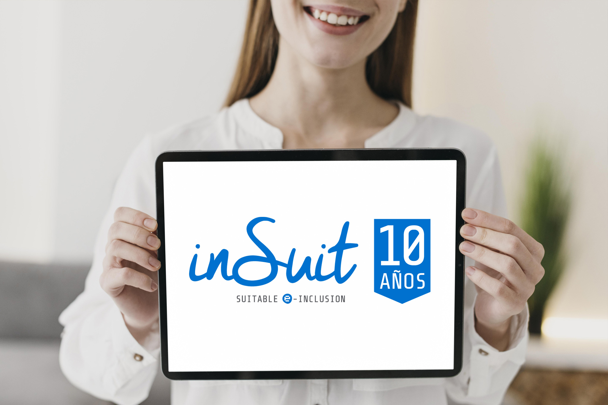 Logo del 10 Aniversario de inSuit sobre una tablet que sostiene una mujer con discapacidad.